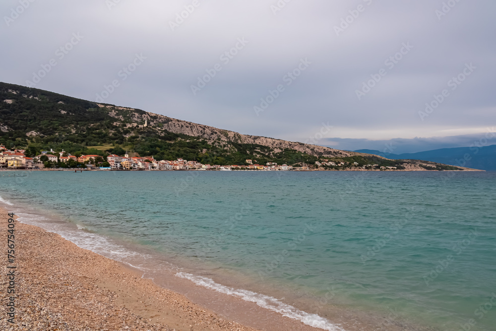 Paradise pebble beach in idyllic coastal town Baska, Krk Island, Primorje-Gorski Kotar, Croatia, Europe. Panoramic view of majestic coastline of Mediterranean Adriatic Sea in summer. Overcast day