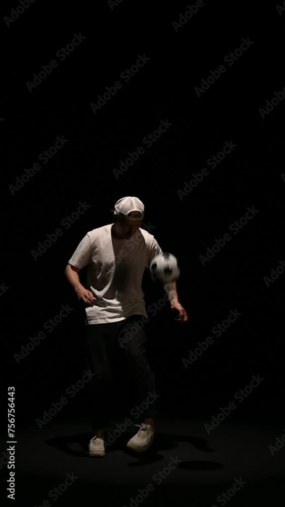 football freestyle performed by a young guy on a black background with a ball. High quality footage football freestyle performed by a young guy on a black background with a ball. High quality footage