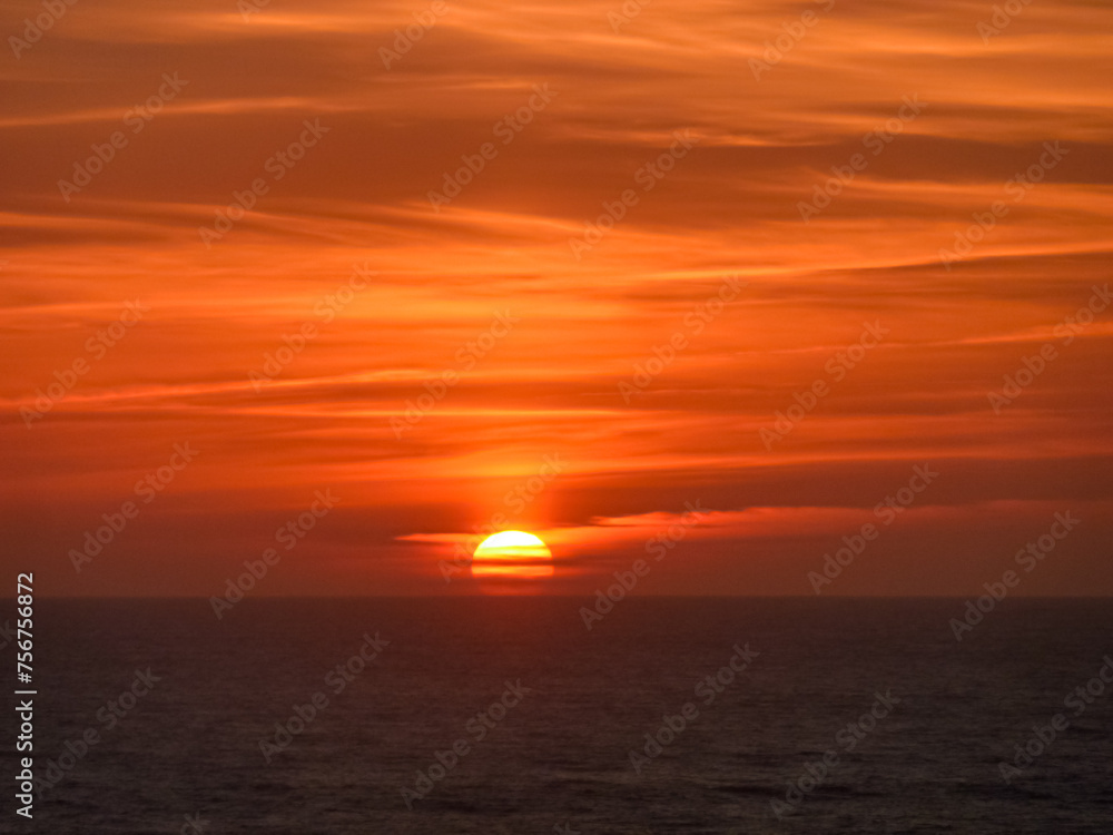 Watching romantic sunset overlooking the calm waters of the sea in  Ericeira, Portugal, Europe. Looking at majestic Atlantic Ocean. Serene tranquil vacation. Empty tropical landscape in summer