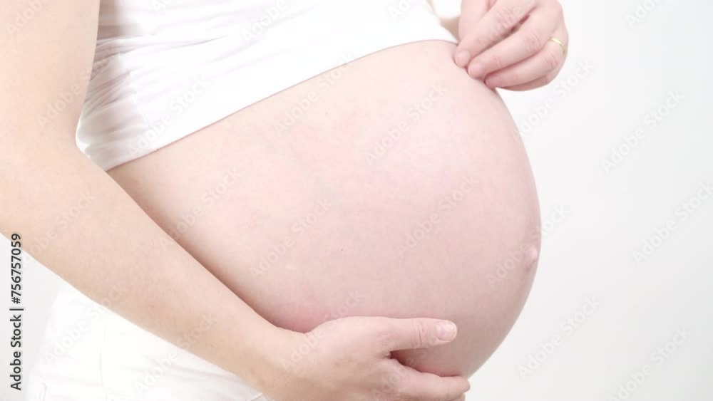 A brief moment in my tummy, forever in my heart. The young woman is pregnant. She loves her newborn baby by stroking its tummy. White background. A brief moment in my tummy, forever in my heart. The young woman is pregnant. She loves her newborn baby by stroking its tummy. White background.