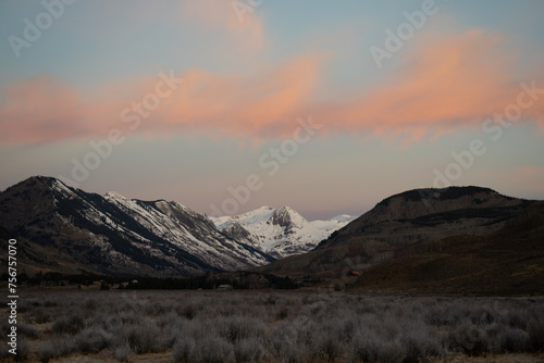 Pink and orange clouds illuminated by the sunrise over the paradise divide mountains near Crested Butte, Colorado