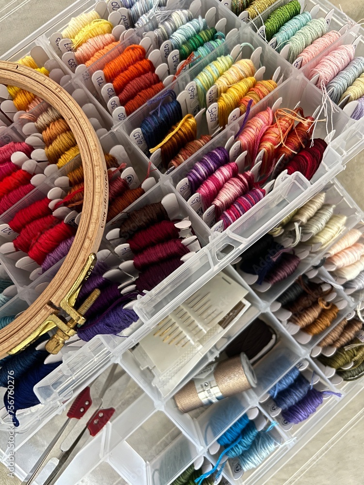 needles and colorful threads for embroidery in a craft box