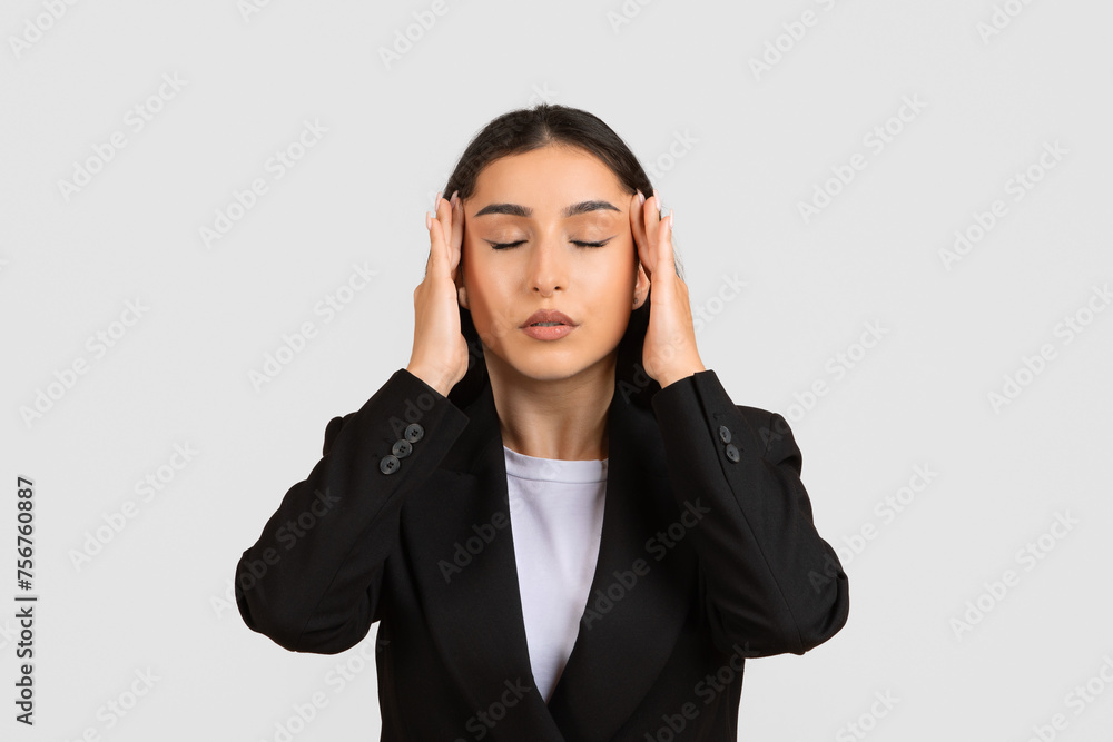 Stressed businesswoman with headache, touching temples with closed eyes Stressed businesswoman with headache, touching temples with closed eyes