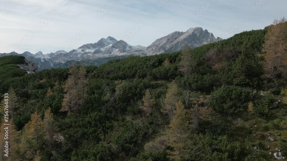 view from the top of the mountain. the drone rises and a view of high mountains and clouds opens up