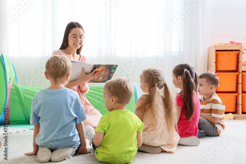 Nursery teacher reading sto...