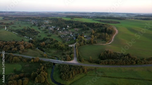 Rural landscape. Country houses in countryside. Village Home at farm field. Roofs of Wooden house in Russian village. Agricultural field with Suburban house. Cuntryside on sunset, aerial view.  photo