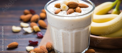 A nonalcoholic beverage made with dairy and frozen dessert, this milkshake combines almonds and bananas in a glass on a wooden table