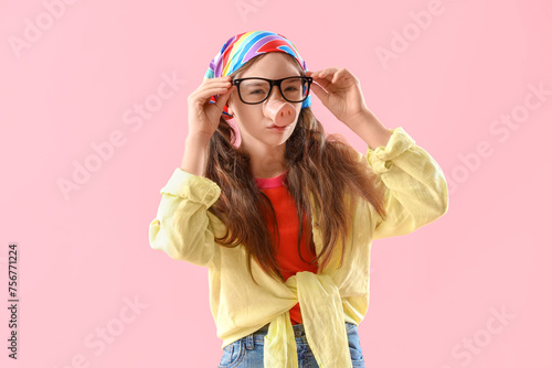 Funny little girl in disguise on pink background. April Fools' Day celebration