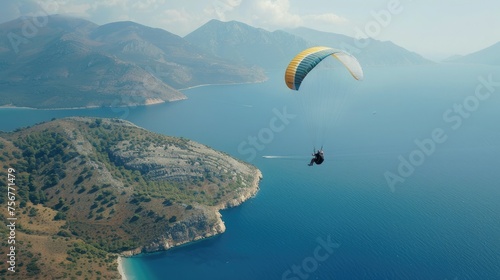 the paraglider against the backdrop of the sea with blue water and mountains, showcasing the beauty and vastness of the landscape