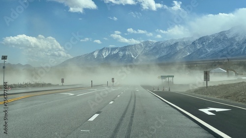 Dust clouds from nearby construction work, blow across and reduce visibility on freeway, at Fort Independence Reservation, California