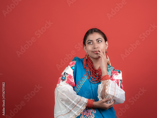 latin girl of kichwa origin looking incredulous with a red background photo
