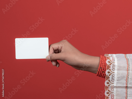 kichwa woman's hand with red handles holding a credit card with red background photo