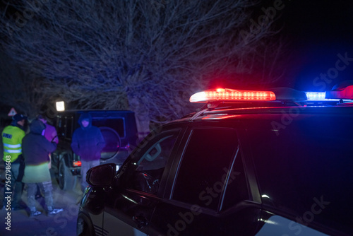 police officer stands next to a car he pulled over for speeding, reaching for the driver's ID, stock photo photo