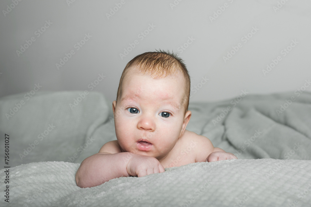 Innocent Baby Gazing Curiously While Lying on a Soft Blanket Indoors