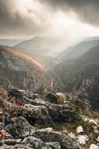 Morning shot of river canyon with lots of trees and cliffs, with road and railway going through, during winter, river Djetinja, Uzice, Serbia photo