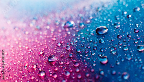 The background features a blend of blue, pink, and purple colors, with water droplets scattered throughout. The droplets create a shiny and reflective surface, adding texture