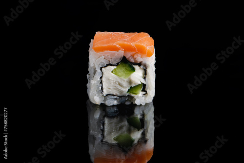 Philadelphia sushi roll on black background with reflection. Uramaki rolls.