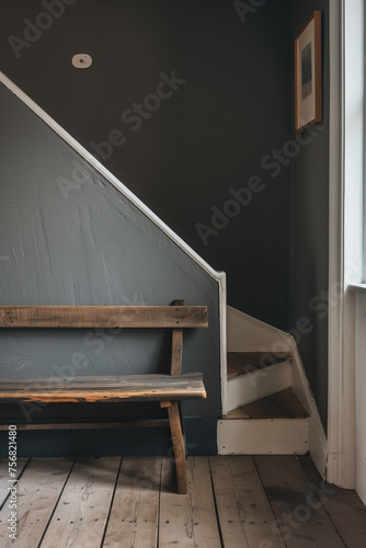 Wooden bench against grey wall and staircase. Scandinavian  rustic farmhouse interior design of modern entryway
