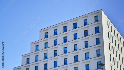 View of a white modern apartment building. Perfect symmetry with blue sky. Geometric architecture detail modern concrete structure building. Abstract concrete architecture. 