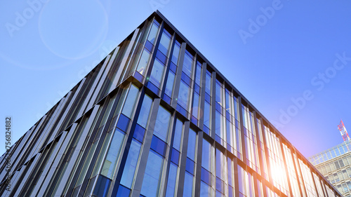 Modern office building with glass facade. Transparent glass wall of office building. Reflection of the blue sky on the facade of the building.