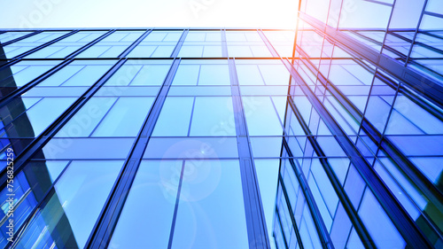 Modern office building with glass facade. Transparent glass wall of office building. Reflection of the blue sky on the facade of the building.