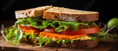 A sandwich made with staple ingredients like lettuce, tomatoes, and carrots, all placed on a wooden cutting board. This dish combines fresh produce with baked goods for a tasty meal