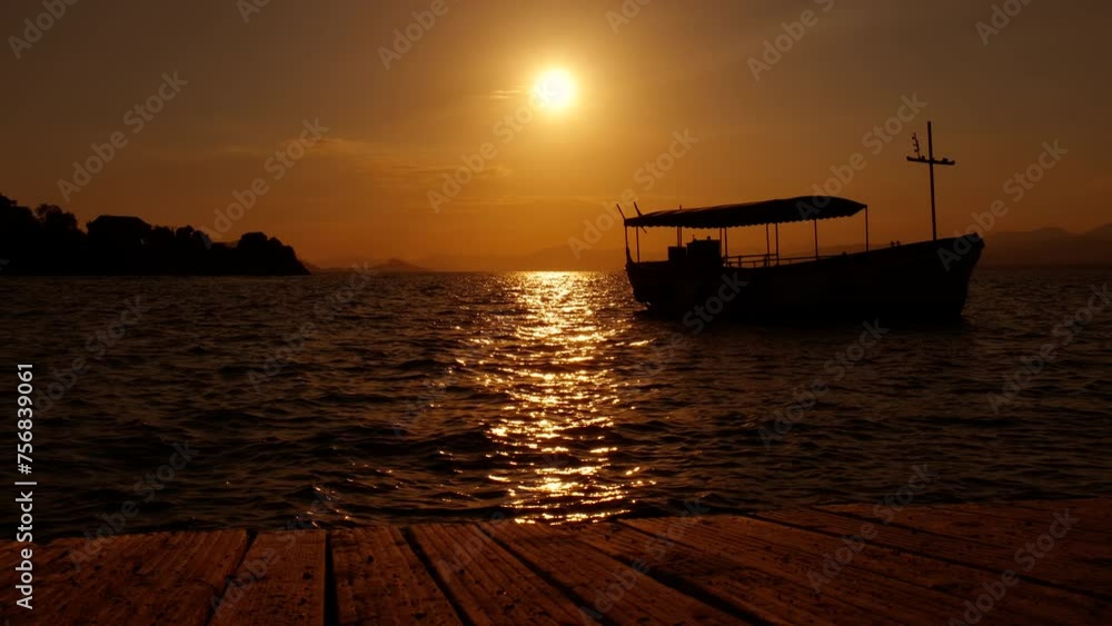 Sunset clouds over anchored yacht. A view of bright sunset time over harbor with docked sailboat in summer. Sunset clouds over anchored yacht. A view of bright sunset time over harbor with docked sailboat in summer.