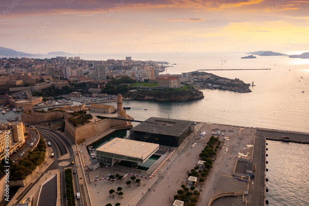 Aerial view of seaside area of French city of Marseille on Mediterranean coast overlooking medieval Fort Saint-Jean on background