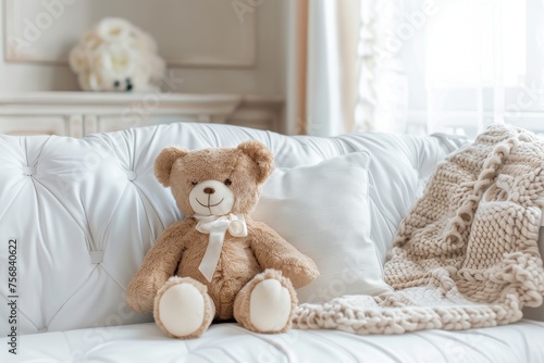 Teddy bear on white sofa with pillow and knitted blanket