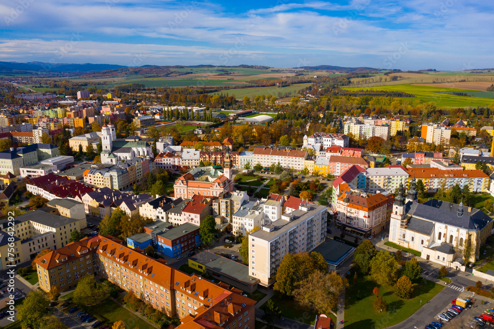 Panoramic aerial view of autumn landscape of Czech town of Krnov with white building of St. Martin church and Town hall on main square on sunny day, Moravian-Silesian Region..