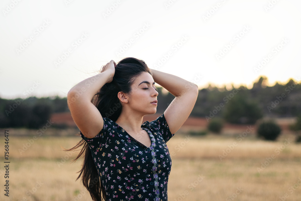 Portrait of a pretty young woman with long hair in the countryside