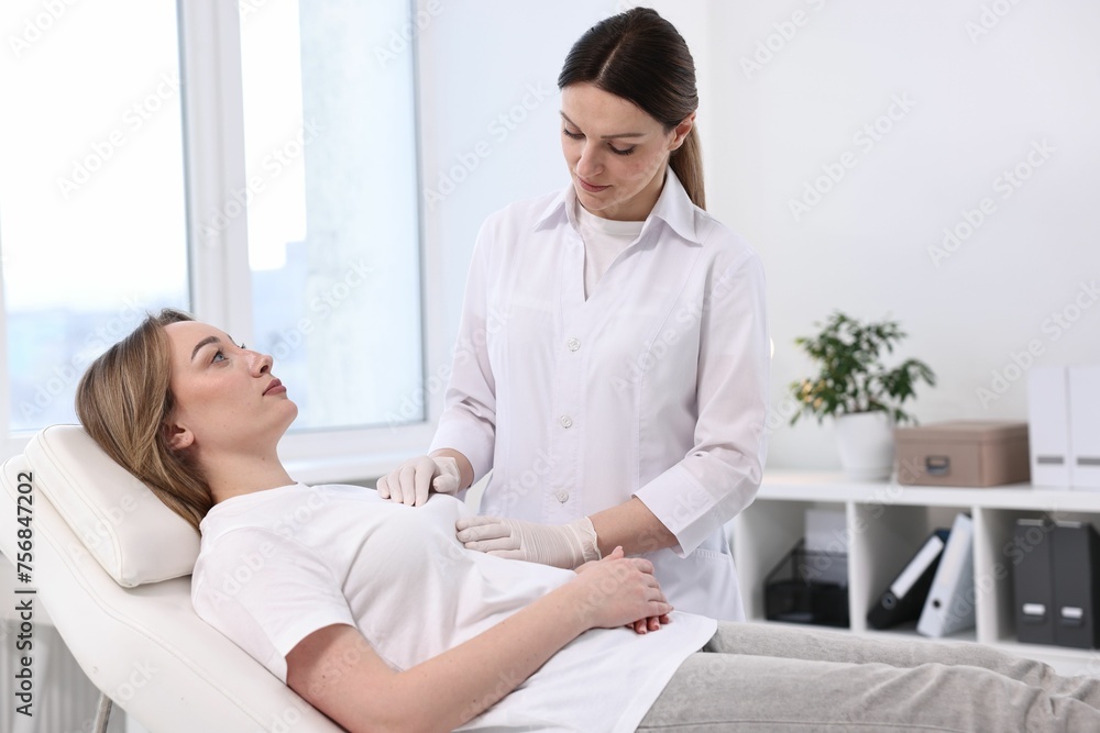Mammologist checking young woman's breast in hospital Mammologist checking young woman's breast in hospital