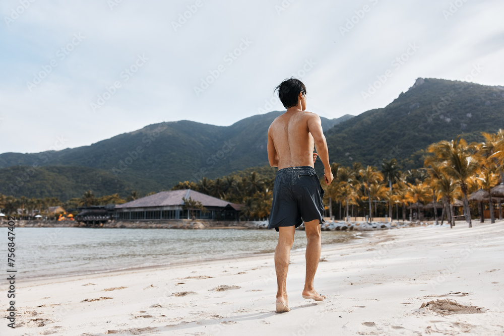 Muscled Asian Athlete Running on Sand at Beach: A Portrait of Strength, Freedom, and Healthy Lifestyle