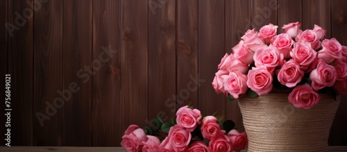 Two vases filled with pink roses grace a wooden table  creating a lovely floral arrangement. The vibrant magenta petals brighten up the room by the window