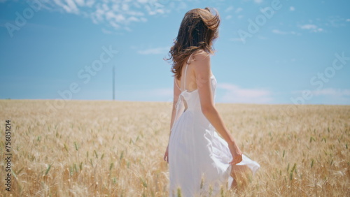 Beaming lady walking sunny wheat farmland. Happy girl spinning summer nature