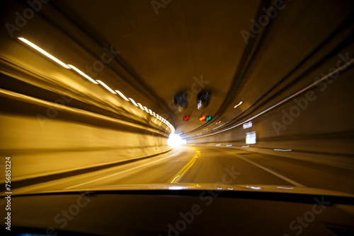 Movimiento rápido. Transitando un túnel curvo en alta velocidad desde un automóvil. Luces ámbar barridas por la rapidez del movimiento. Luz al final del camino. Carretera mexicana. photo