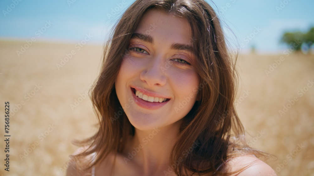 Sunny lady smiling meadow portrait. Young woman looking camera at summer field Sunny lady smiling meadow portrait. Young woman looking camera at summer field