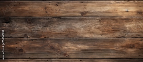 A close up of a brown hardwood plank wall with a wood stain finish. The blurred background highlights the intricate pattern of the building material in a beige tone