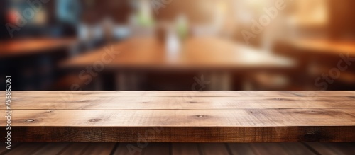 A rectangular brown wooden table with a glossy varnish finish sits in a restaurant, blending into the hardwood plank flooring with blurred background