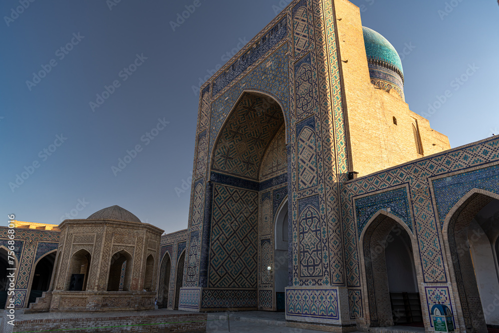 View to Mir i Arab madrassa through old wooden carved door, Bukhara, Uzbekistan
