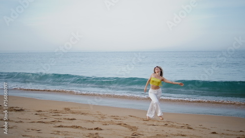 Sensual girl dancing improvisation in modern style at sand beach. Woman spinning