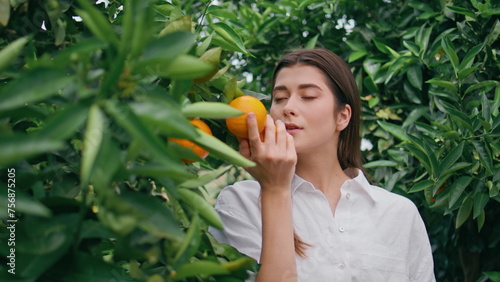 Happy lady smell citrus fruit at nature closeup. Woman enjoying orange aroma