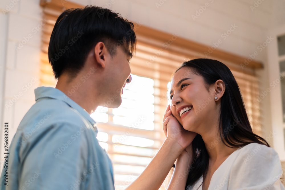 Naklejka premium Asian young man and woman looking each other in living room at home. 