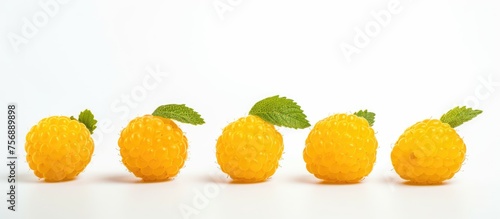 A colorful display of Rangpur  Valencia orange  Clementine  and Bitter orange sitting on a tableware  accompanied by a row of yellow raspberries with mint leaves on a white background