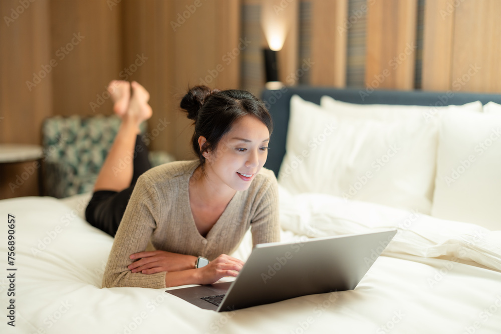 Woman watch on laptop computer and lying on bed at home Woman watch on laptop computer and lying on bed at home