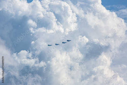 積乱雲を背景に空を飛ぶ戦闘機