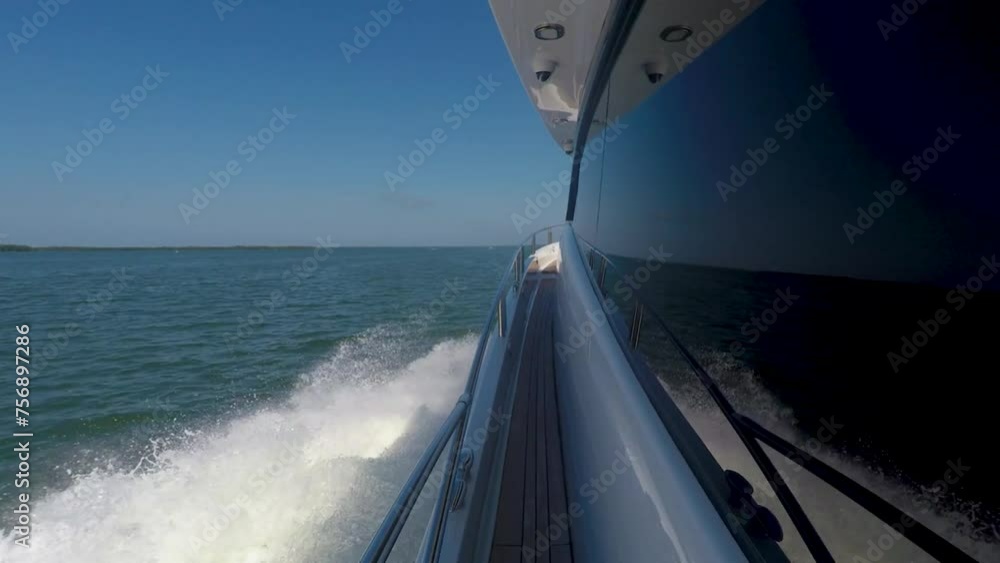 Walking along the railing of a yacht as it is cruising in the Gulf of