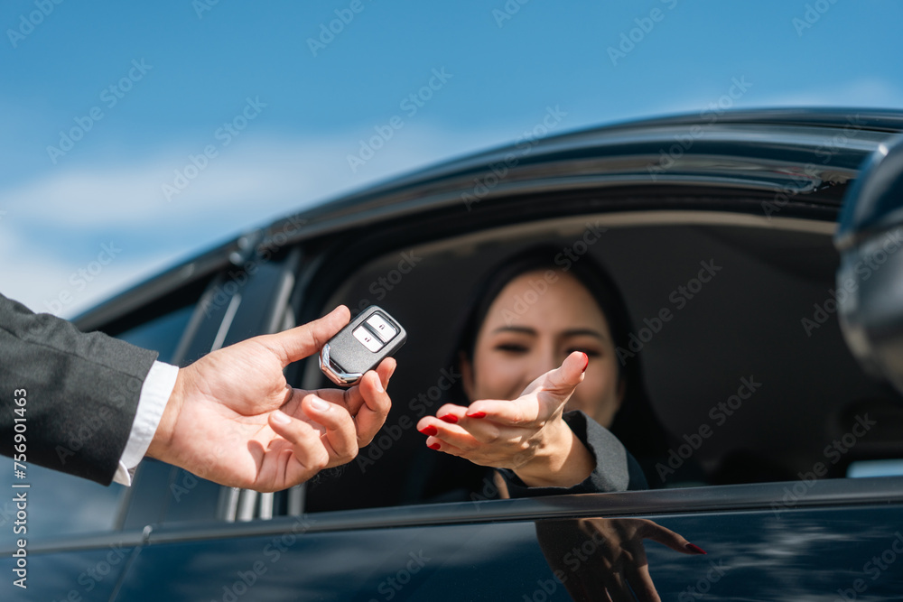 Young asian businesswoman buying new car with sale manager. she getting key and go to driving car very happy and proud. Buy sell rent concept. Hand sending key vehicle contract business car deal - obrazy, fototapety, plakaty 