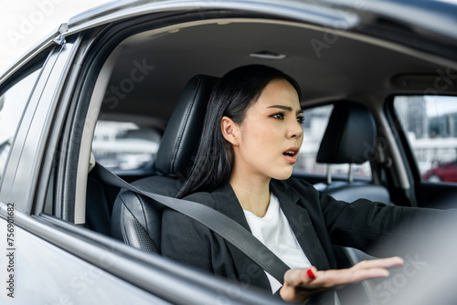 Driving during rush hour But the traffic is very congested. Angry face. Young asian businesswoman has broken down car on the road she feeling serious and stressed. Car crash Look for someone help. © Chanakon
