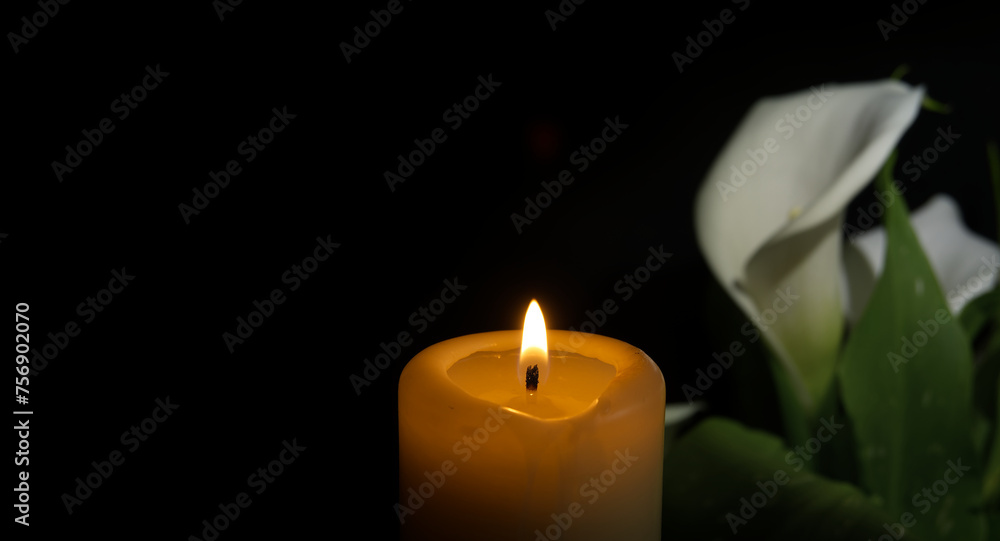 Burning wax candle and white calla lily flowers in darkness Burning wax candle and white calla lily flowers in darkness